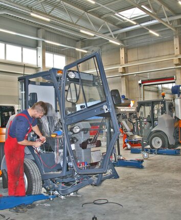 Stangl Werkstatt Kommunaltechnik ein Stangl Techniker repariert eine Kommunalmaschine