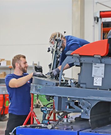 Zwei Stangl Kundendienst Techniker reparieren eine Kehrmaschine